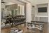 Modern fitness center with a mirrored wall, free weights, and versatile workout benches.