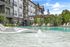 Luxurious apartment complex featuring elegant poolside lounging area with comfortable sun beds and modern pergola.