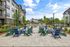 Charming outdoor patio area with colorful Adirondack chairs and string lights, perfect for social gatherings in a modern apartment community.