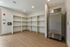 Modern storage area with sleek shelving and stainless steel refrigerator, ideal for maximizing space and organization.