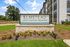 Inviting sign for Elmstead luxury apartment residences with vibrant landscaping and modern exterior design.
