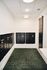Modern mailroom with sleek black mailboxes and chic green carpet in an upscale apartment complex.