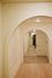 Inviting hallway featuring elegant archways and modern lighting, leading to a stylish apartment entrance.