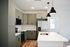 Modern kitchen with sleek green cabinetry, stainless steel appliances, and a stylish island with pendant lighting.