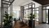 Modern and stylish open-plan office space with large windows, elegant furnishings, and lush green plants, offering a bright and welcoming environment with scenic views.