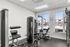 Modern apartment gym with state-of-the-art equipment and large windows overlooking a sparkling outdoor pool.