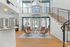 Elegant apartment with an open-concept living space, featuring a modern staircase, high ceilings, and abundant natural light through large windows.
