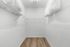Spacious walk-in closet with elegant hardwood flooring and ample white shelving for organized storage.