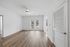 Bright, open-concept living space with sleek hardwood floors, modern ceiling fan, and double glass doors leading to outdoor view.