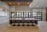 Contemporary communal area with stylish bar seating, geometric wall design, and large windows offering a scenic view.