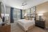 Elegant bedroom with stylish decor, featuring a cozy king-sized bed, chic bedside tables with lamps, and modern abstract artwork on the wall.