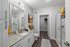 Contemporary bathroom with elegant granite countertop, sleek vanity mirror, and spacious shower with glass doors. Modern decor and inviting neutral tones.