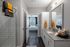 Elegant bathroom with granite countertops, stylish lighting, and cozy bedroom view with chic decor.