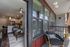 Modern apartment interior with open-concept kitchen, stylish living area, and inviting balcony featuring cozy seating.