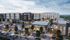 Vibrant urban development featuring modern apartment buildings, bustling shops, and lively outdoor dining spaces, creating a vibrant community atmosphere.