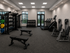 Modern fitness center featuring a variety of exercise equipment including treadmills, weight racks, and resistance machines, offering a well-equipped space for a complete workout.