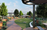 Inviting outdoor lounge area with lush greenery, modern pathways, and elegant pergolas, perfect for relaxation and leisure.