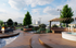 Luxurious outdoor terrace featuring a modern fire pit, elegant seating, lush greenery, and a stylish pergola with a scenic city view.