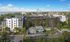 Modern urban apartment complex with lush landscaping, offering stunning city views and proximity to serene waterfront.