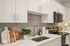 Modern kitchen with sleek countertops, stainless steel appliances, and elegant cabinetry, accented by stylish cutting boards and a decorative plant.