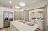 Modern kitchen and laundry area featuring sleek appliances, a spacious island with elegant place settings, and stylish pendant lighting.