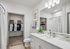 Bright and modern bathroom with sleek vanity, lush plant accents, and convenient walk-in closet.