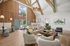 Luxurious and spacious living area featuring high ceilings, elegant wood paneling, plush seating, and modern decor, offering a warm and inviting ambiance.