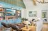 Bright and inviting living room with stylish built-in shelves, cozy seating area, and a large landscape painting enhancing the modern decor.