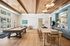 Elegant open-concept space featuring a luxurious billiards table, stylish seating, and a modern kitchen with chic light fixtures and wood accents.
