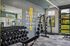 Modern apartment gym with sleek equipment, motivational quote, and bright natural light.