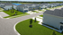 Charming suburban community with modern townhouses, neatly landscaped lawns, and convenient parking areas, set against a picturesque lake backdrop.