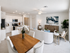 Elegant open-concept living space with a modern kitchen, cozy seating area, and stylish dining table, perfect for entertaining.