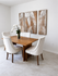 Elegant dining area featuring a wooden table, four upholstered chairs, and tropical-themed wall art.