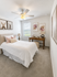 Bright and cozy bedroom with modern decor, featuring a plush bed, elegant artwork, and ample natural light.