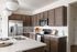 Contemporary kitchen with sleek stainless steel appliances, elegant dark wood cabinetry, and a chic quartz countertop island.