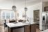 Bright and modern kitchen with sleek appliances, large island, and open layout flowing into a cozy dining area with natural light.