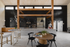 Contemporary spacious living area with elegant wooden beams, modern kitchen, and chic dining space complemented by stylish black pendant lights.