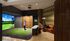 Luxurious apartment amenity featuring a modern virtual golf simulator with comfortable lounge seating, offering a unique recreational experience.