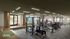 Modern fitness center with state-of-the-art gym equipment, spacious design, and floor-to-ceiling windows overlooking lush outdoor scenery.