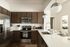 Modern kitchen with sleek stainless steel appliances, elegant brown cabinetry, and a spacious countertop with stylish pendant lighting.