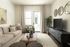 Chic living room with elegant decor, cozy beige sofa, sleek dark TV stand, and natural light streaming through large windows and glass door.