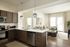 Modern open-concept apartment featuring a sleek kitchen with stainless steel appliances, stylish lighting, and a cozy living area with natural light and elegant decor.
