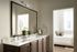 Elegant bathroom with dual sink vanity and a view into a cozy, light-filled bedroom.