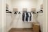 Spacious walk-in closet with elegant shelving, black hangers, and organized storage baskets.