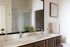 Elegant bathroom with dual sinks, modern fixtures, and a stylish glass shower enclosure.