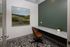 Chic home office space featuring a modern desk, comfortable leather chair, and elegant wall art against a stylish green wall.