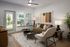 Chic contemporary living room featuring a cozy sofa, modern accent chair, and stylish decor, flooded with natural light from large windows.