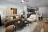 Modern living space featuring plush seating, stylish art, and an open-plan kitchen with a sleek breakfast bar.