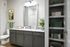 Modern bathroom with stylish gray cabinetry, granite countertops, vibrant green towels, and elegant decor accents for a luxurious feel.