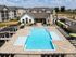 Luxurious apartment complex with a beautifully designed pool, spacious sundeck, and modern clubhouse surrounded by stylish apartments.
